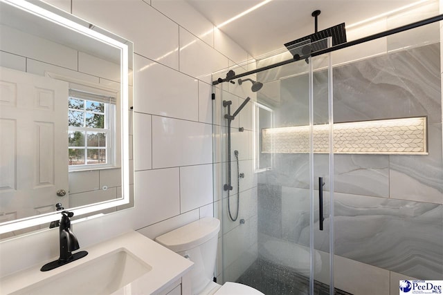 bathroom featuring vanity, toilet, tile walls, and a shower with shower door