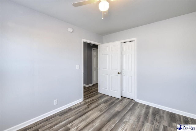 unfurnished bedroom with a closet, a ceiling fan, baseboards, and wood finished floors