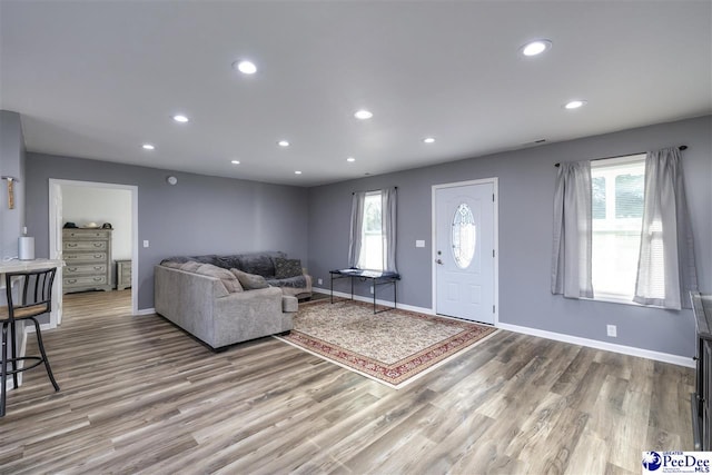 living area with recessed lighting, a healthy amount of sunlight, and wood finished floors