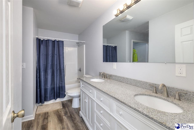 bathroom featuring a sink, visible vents, toilet, and wood finished floors