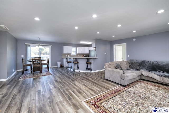 living room featuring visible vents, recessed lighting, wood finished floors, and baseboards