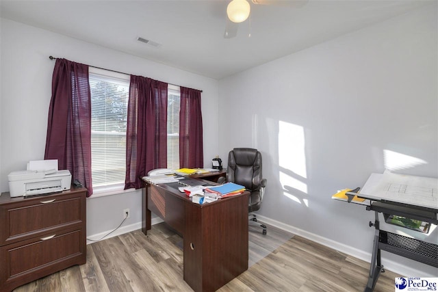 office featuring visible vents, light wood-style flooring, baseboards, and ceiling fan