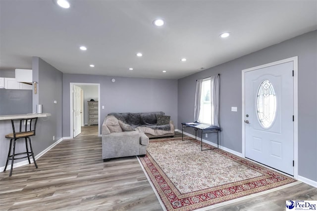 living area with wood finished floors, recessed lighting, and baseboards