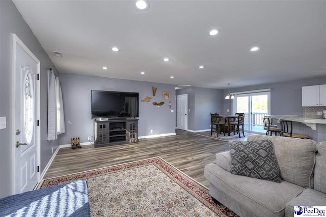 living room featuring visible vents, recessed lighting, baseboards, and wood finished floors