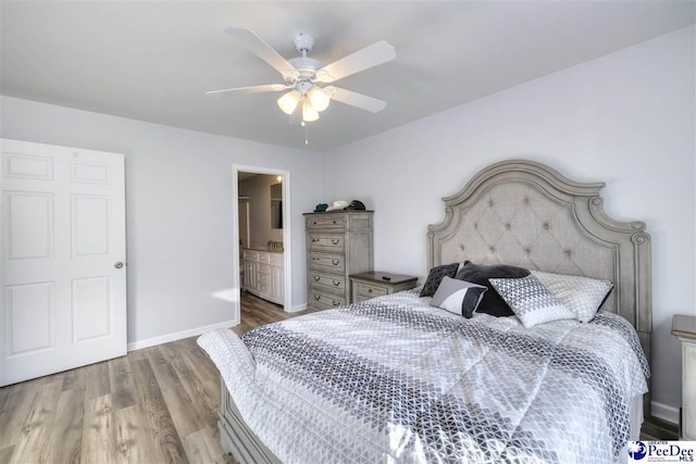 bedroom with a ceiling fan, wood finished floors, baseboards, and ensuite bathroom