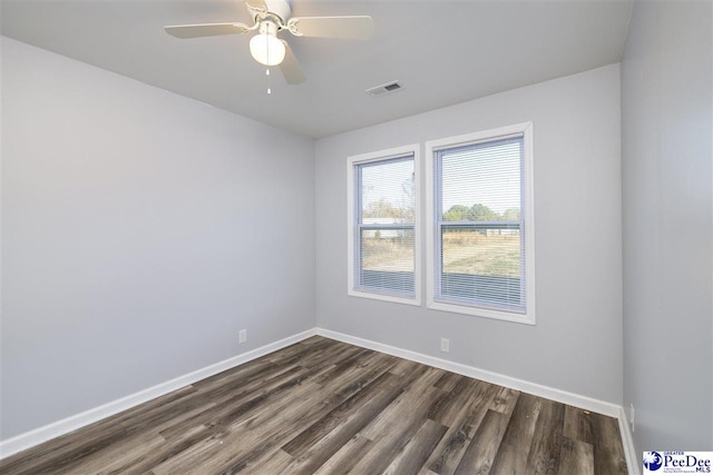 unfurnished room featuring dark wood-style floors, visible vents, ceiling fan, and baseboards