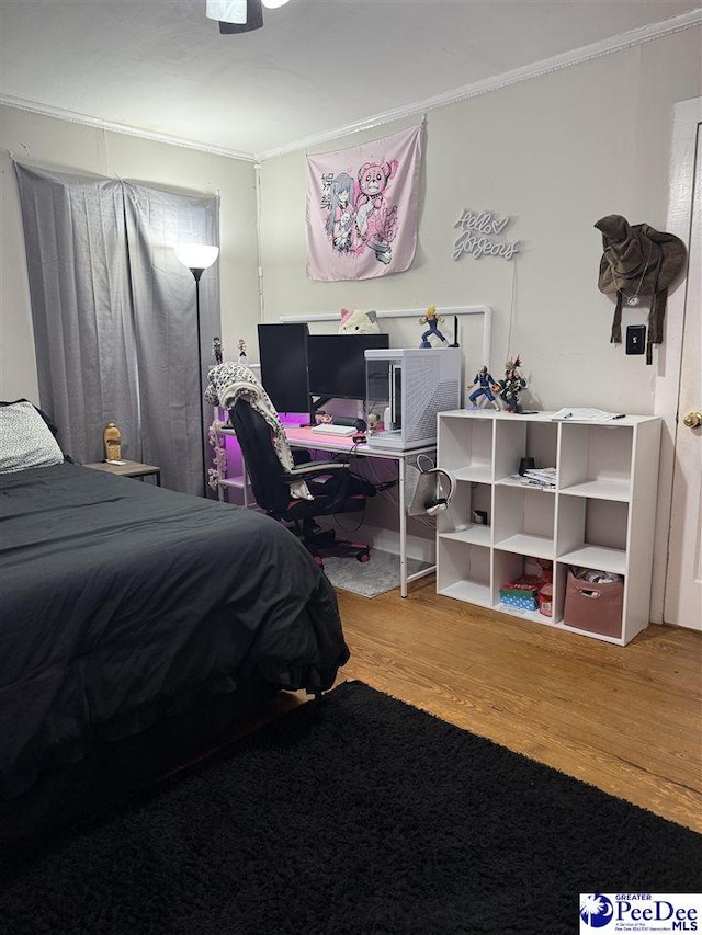 bedroom with wood-type flooring and ornamental molding