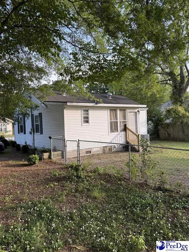 view of front of house with fence, a gate, and crawl space