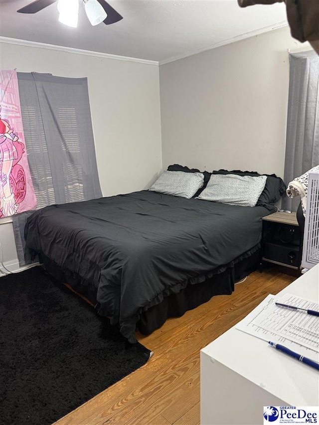 bedroom with ceiling fan, ornamental molding, and wood-type flooring