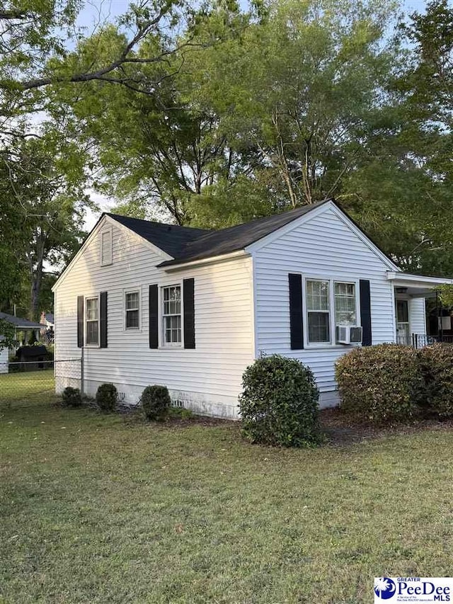 view of property exterior with fence, cooling unit, and a yard