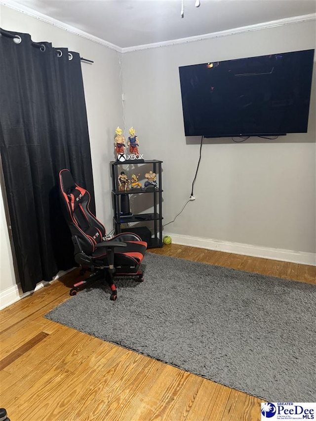 living area featuring hardwood / wood-style flooring and crown molding