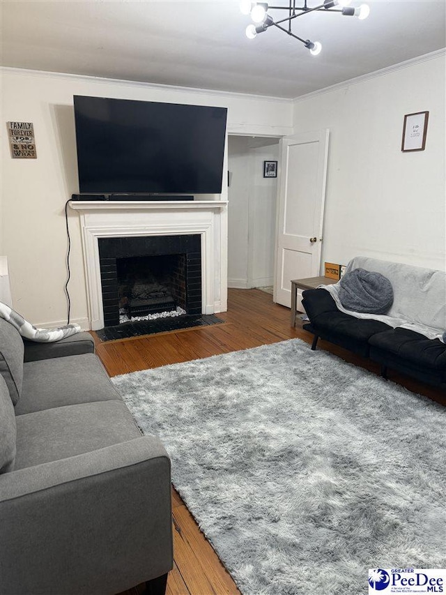 living room featuring ornamental molding, dark wood-type flooring, and a chandelier