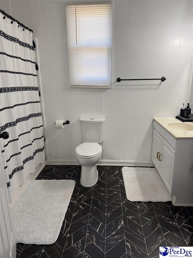 bathroom with vanity, tile walls, walk in shower, and toilet