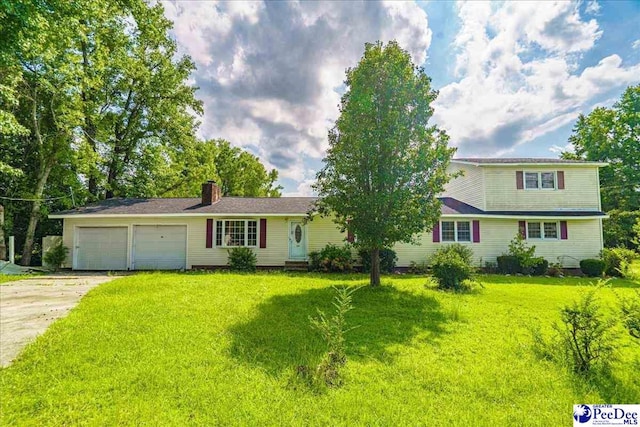 view of front of property featuring a garage and a front lawn