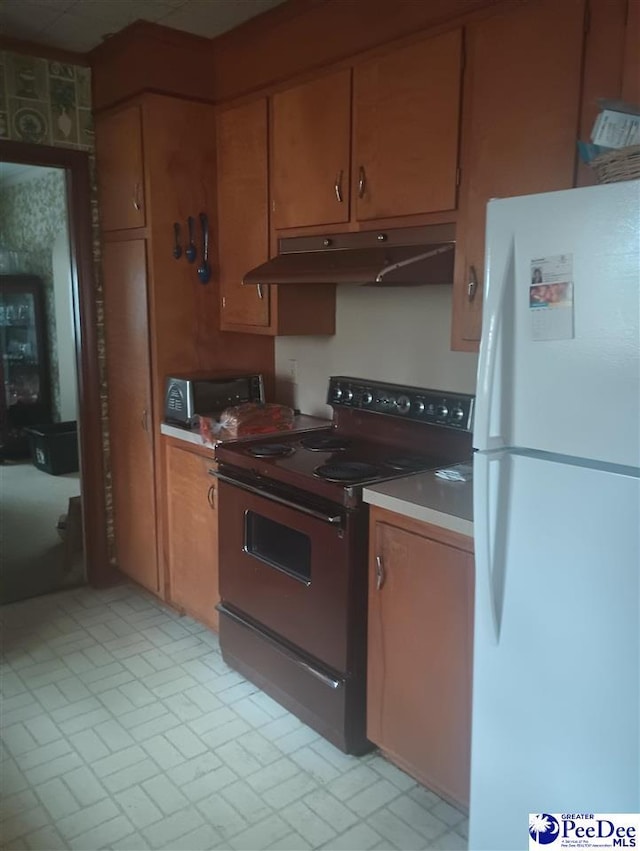 kitchen with freestanding refrigerator, black electric range, brown cabinets, and under cabinet range hood