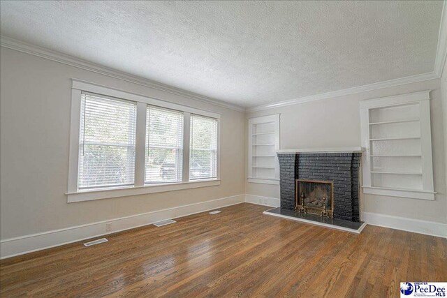 904 Madison Ave, Florence, SC 29501 - unfurnished living room featuring a textured ceiling, built in shelves, a fireplace, baseboards, and wood finished floors