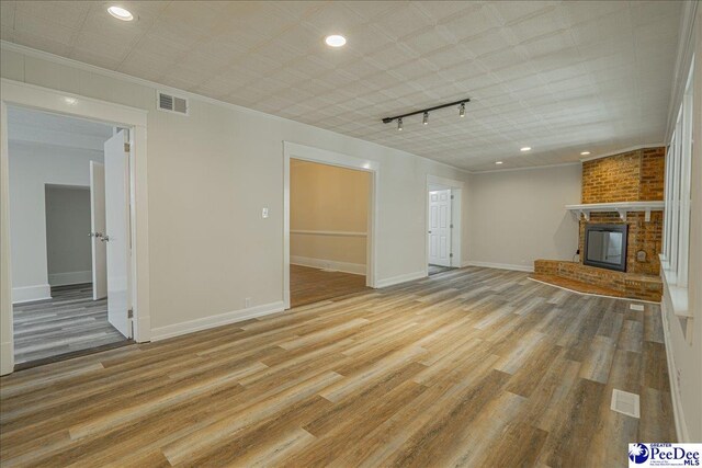 904 Madison Ave, Florence, SC 29501 - unfurnished living room with a brick fireplace, track lighting, light wood finished floors, baseboards, and recessed lighting