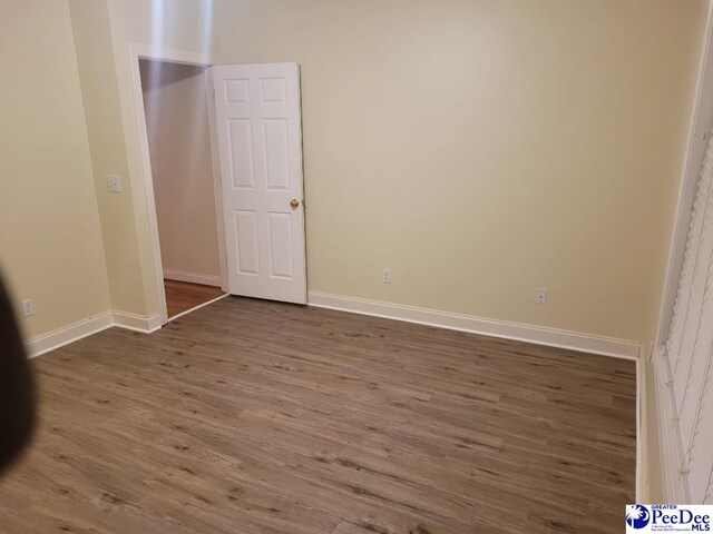 3675 W Pointe Dr, Florence, SC 29501 - unfurnished bedroom featuring dark wood-style floors and baseboards