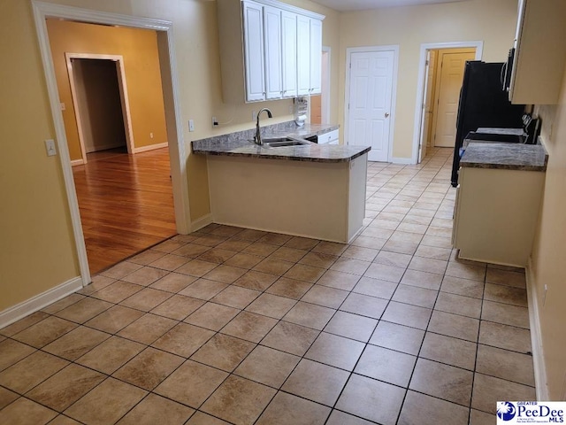 3675 W Pointe Dr, Florence, SC 29501 - kitchen featuring light tile patterned floors, white cabinetry, a peninsula, and fridge