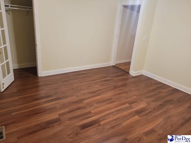 3675 W Pointe Dr, Florence, SC 29501 - unfurnished bedroom with a closet and dark wood-style flooring