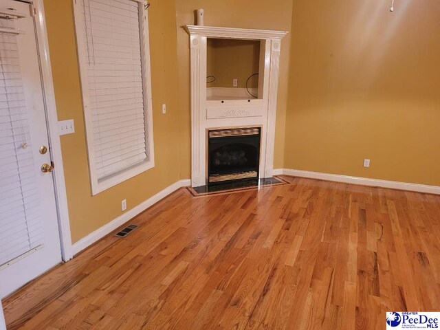 3675 W Pointe Dr, Florence, SC 29501 - unfurnished living room with light wood finished floors and a fireplace