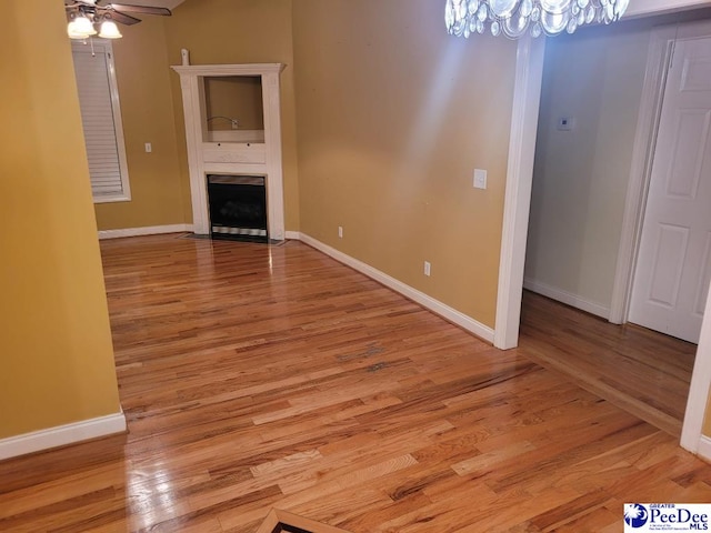 3675 W Pointe Dr, Florence, SC 29501 - unfurnished living room with a chandelier, light wood-style floors, a fireplace with flush hearth, and a ceiling fan