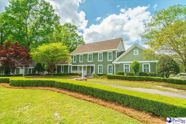 colonial inspired home with a front lawn