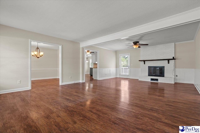 1526 Hunter St, Florence, SC 29505 - unfurnished living room with a ceiling fan, a chandelier, wood finished floors, a wainscoted wall, and a textured ceiling