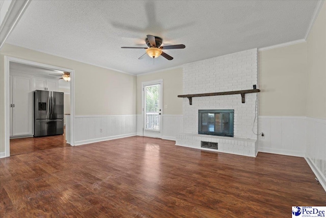 1526 Hunter St, Florence, SC 29505 - unfurnished living room featuring ceiling fan, wainscoting, wood finished floors, a textured ceiling, and ornamental molding