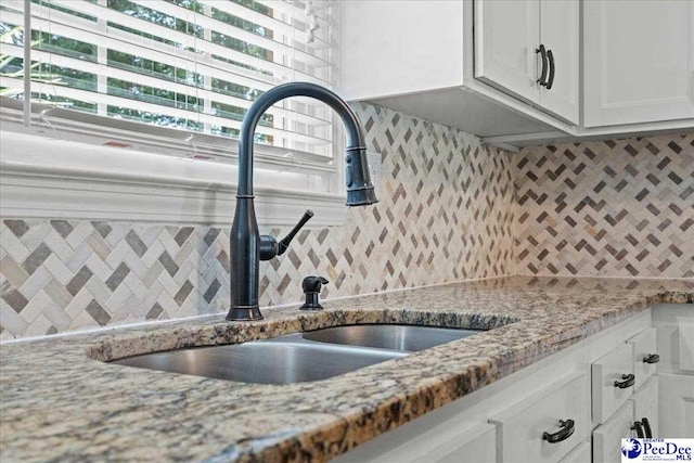 1526 Hunter St, Florence, SC 29505 - kitchen with backsplash, white cabinetry, and light stone countertops