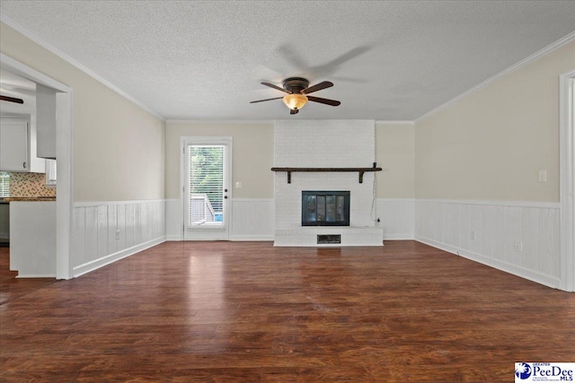 1526 Hunter St, Florence, SC 29505 - unfurnished living room featuring a ceiling fan, dark wood-type flooring, a brick fireplace, wainscoting, and a textured ceiling