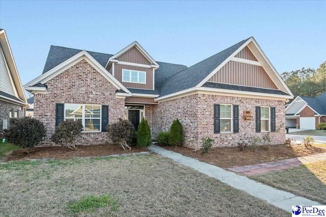 craftsman house featuring a front lawn and brick siding