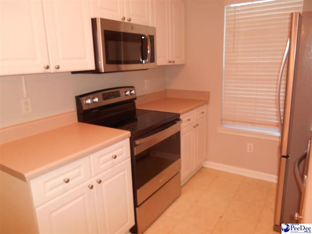 kitchen featuring stainless steel appliances and white cabinets