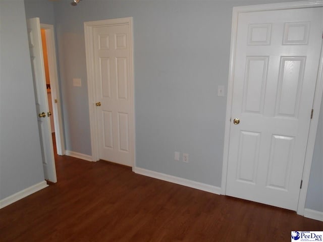 unfurnished bedroom with dark wood-type flooring