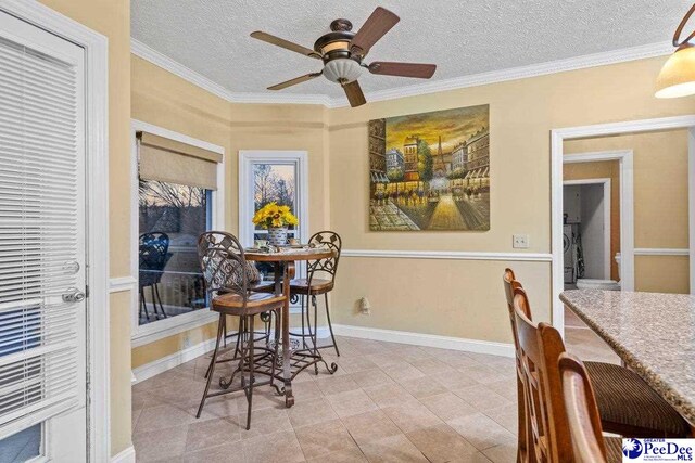 dining area featuring ceiling fan, ornamental molding, and a textured ceiling