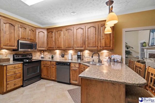 kitchen with sink, a breakfast bar, appliances with stainless steel finishes, decorative light fixtures, and kitchen peninsula