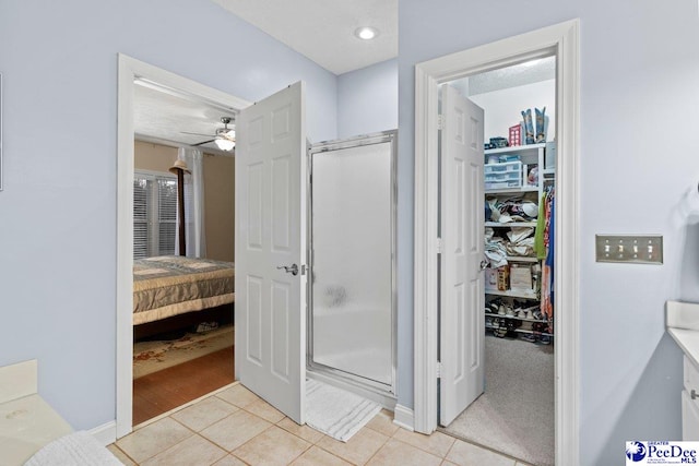 bathroom featuring tile patterned flooring, ceiling fan, a textured ceiling, and a shower with shower door