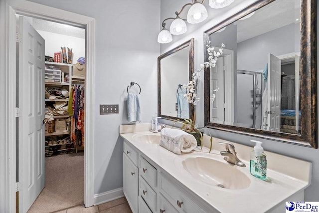 bathroom featuring a shower with door, vanity, and tile patterned flooring