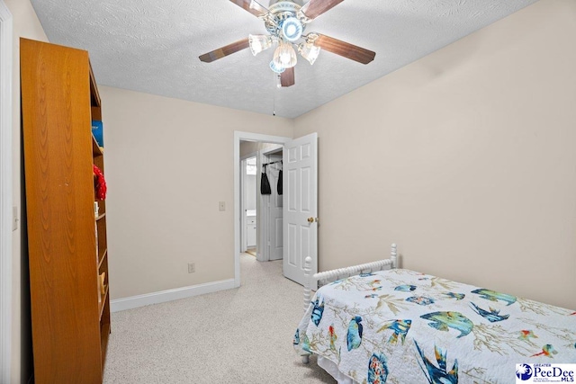 carpeted bedroom featuring ceiling fan and a textured ceiling