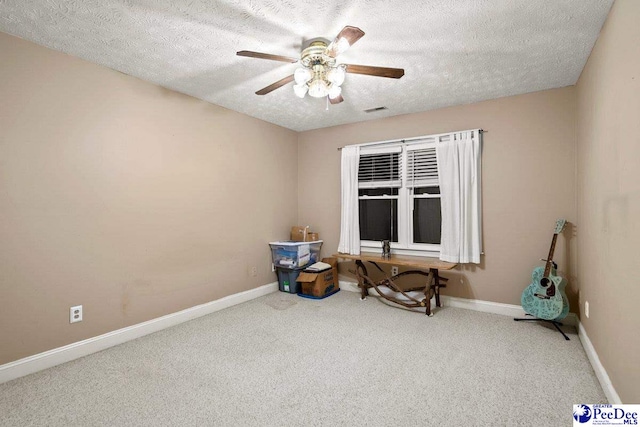 miscellaneous room featuring ceiling fan, carpet flooring, and a textured ceiling