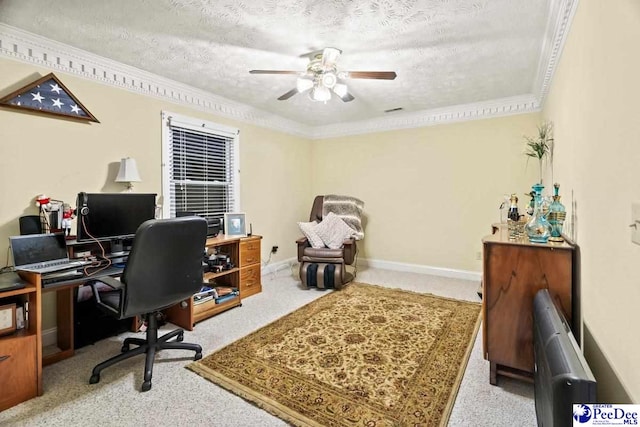 carpeted home office with ceiling fan, ornamental molding, and a textured ceiling