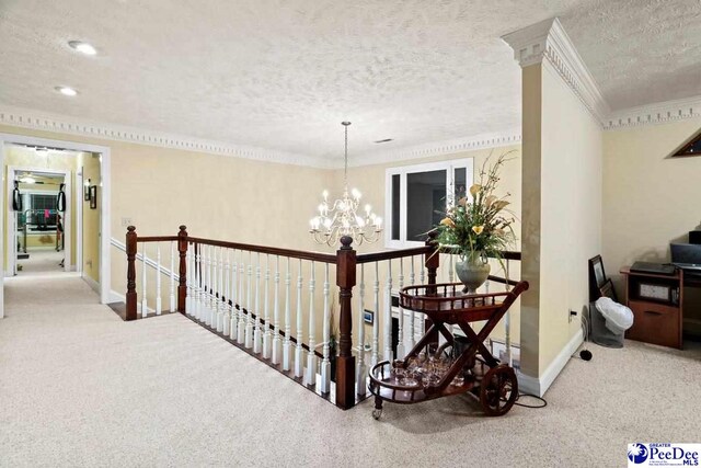 hall with crown molding, a notable chandelier, carpet, and a textured ceiling