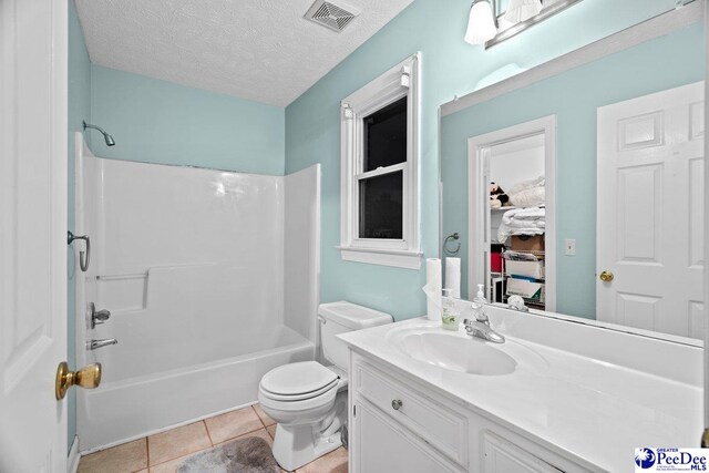 full bathroom featuring toilet, tub / shower combination, a textured ceiling, vanity, and tile patterned flooring