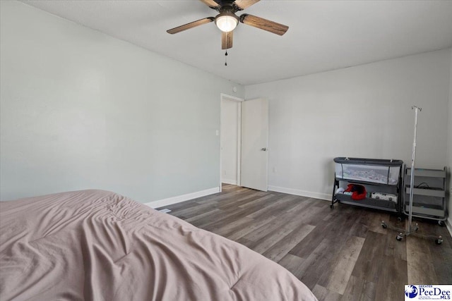 bedroom with ceiling fan, baseboards, and wood finished floors