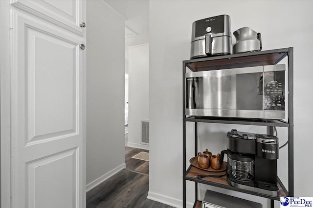 interior space with visible vents, baseboards, and wood finished floors