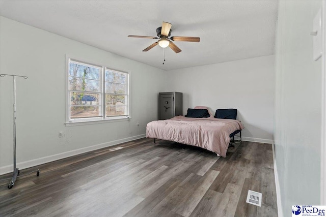 bedroom featuring baseboards, visible vents, ceiling fan, and wood finished floors