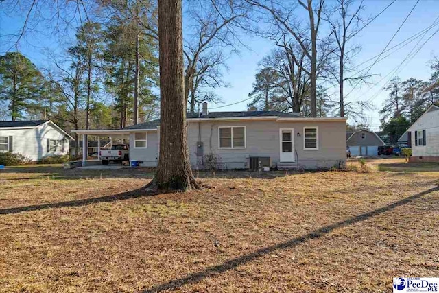 view of front of house with a carport, a front yard, and cooling unit