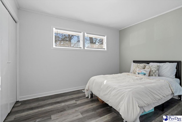 bedroom featuring a closet, crown molding, baseboards, and wood finished floors