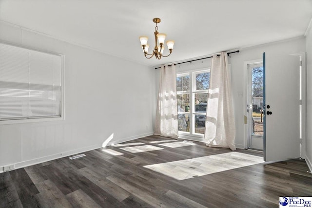 unfurnished dining area featuring baseboards, visible vents, a chandelier, and wood finished floors