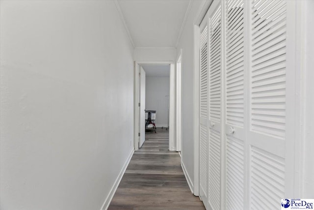 hall featuring ornamental molding, baseboards, and dark wood-style floors